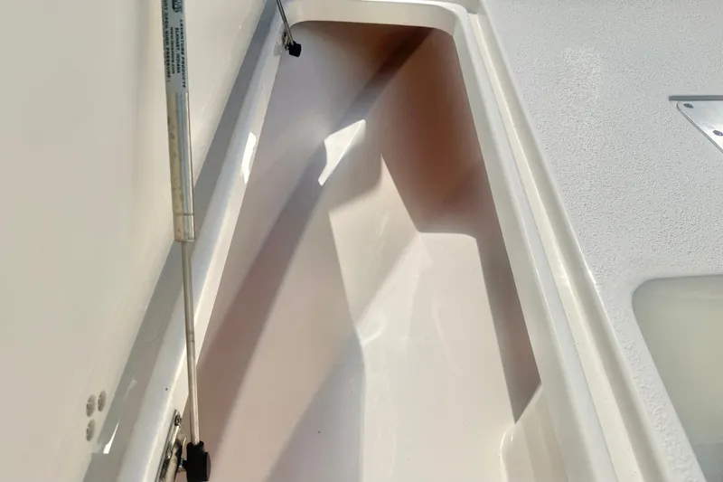 Slide: The Image of Storage compartment of 2027 Carolina Skiff 26 Ultra Elite boat, featuring hydraulic lift support. - 16