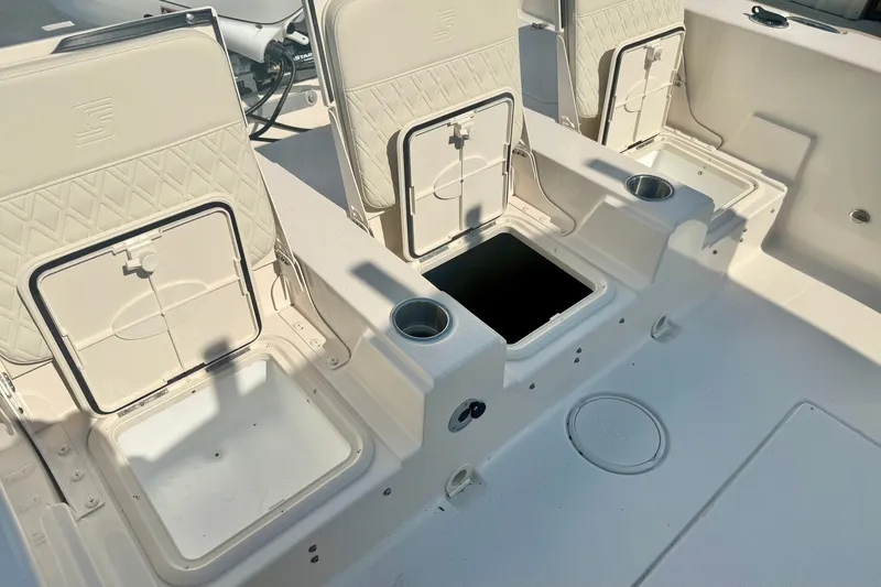 Slide: The Image of 2027 Carolina Skiff 26 Ultra Elite boat interior with open storage compartments and cup holders. - 33