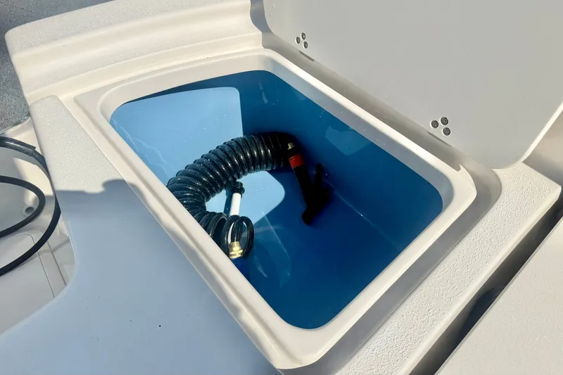 Slide: The Image of Storage compartment with coiled hose on 2027 Carolina Skiff 26 Ultra Elite boat. - 39