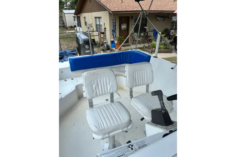 Slide: The Image of 2012 Hurricane Center Console 231 OB boat interior with white seating and Suzuki 150 engine. - 4