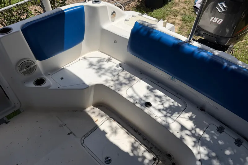 Slide: The Image of 2012 Hurricane Center Console 231 OB boat interior with blue seating and Suzuki 150 outboard motor. - 16