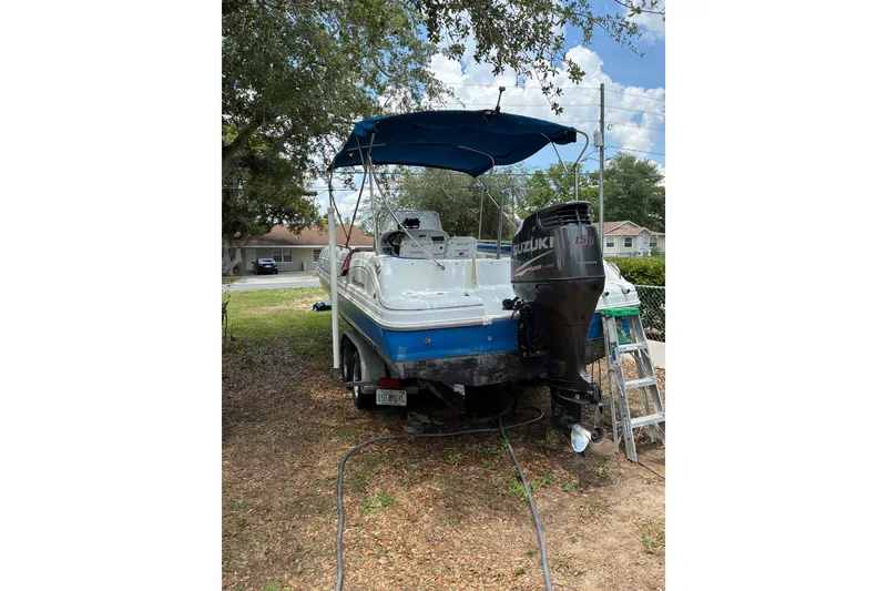 Slide: The Image of 2012 Hurricane Center Console 231 OB boat with Suzuki outboard motor, parked outdoors. - 2