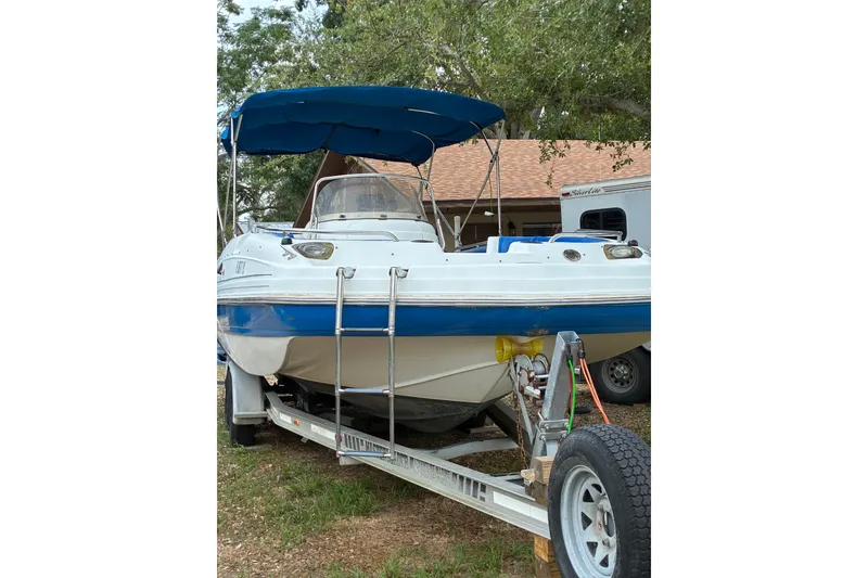 Slide: The Image of 2012 Hurricane Center Console 231 OB boat on trailer with blue canopy. - 1