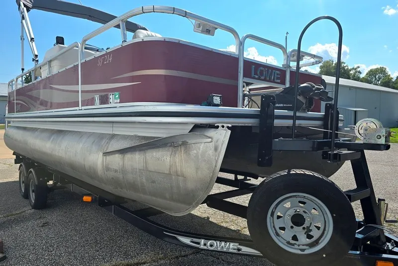Slide: The Image of 2013 Lowe SF 214 Sport Fish pontoon boat on trailer, parked outdoors. - 12