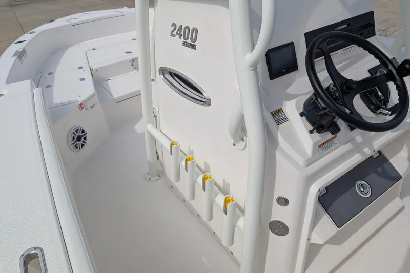 Slide: The Image of The image shows the cockpit of a Pathfinder 2400 Hybrid boat with steering and rod holders. - 16