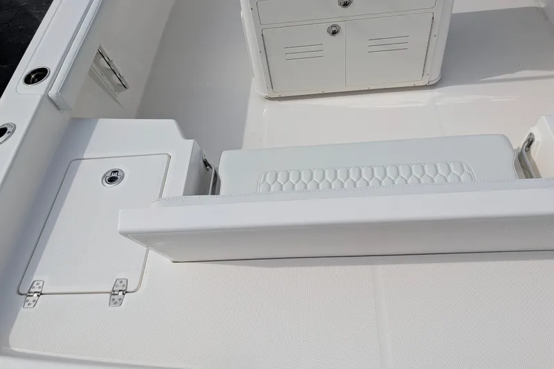 Slide: The Image of The image shows the cockpit of a 2027 Pathfinder 2400 Hybrid boat with white upholstery and storage. - 13