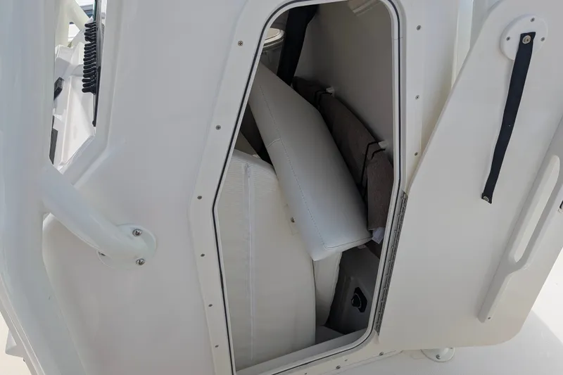Slide: The Image of A small storage compartment on a boat with white cushions and a door. - 23