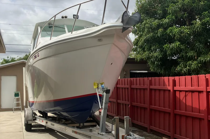 Slide: The Image of 2000 Baha Cruisers 272 Sportfish boat on trailer in driveway. - 9