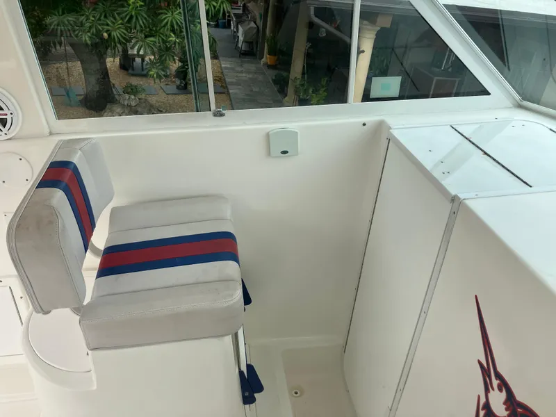 Slide: The Image of Captain's chair on 2000 Baha Cruisers 272 Sportfish boat, white with blue and red stripes. - 23