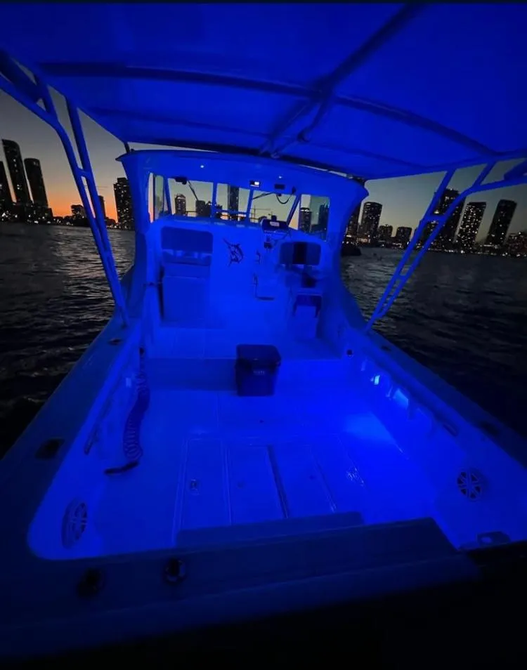 Slide: The Image of Baha Cruisers 272 Sportfish 2000 model illuminated in blue lights at dusk on the water. - 41