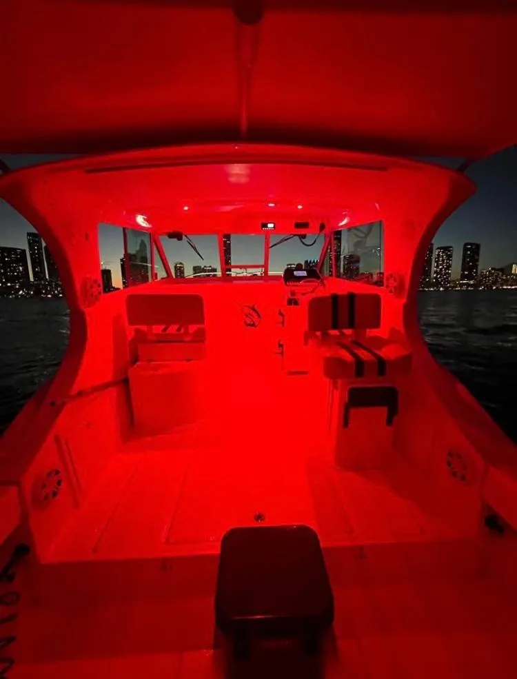 Slide: The Image of 2000 Baha Cruisers 272 Sportfish boat interior illuminated with red lights at night. - 28