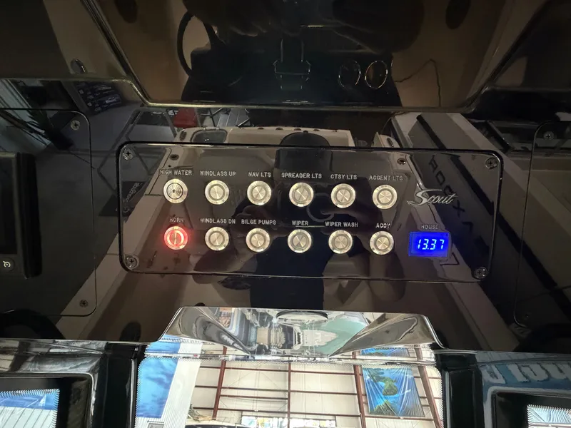 Slide: The Image of Control panel of a Scout 260 LXF boat with various switches and a digital display. - 34