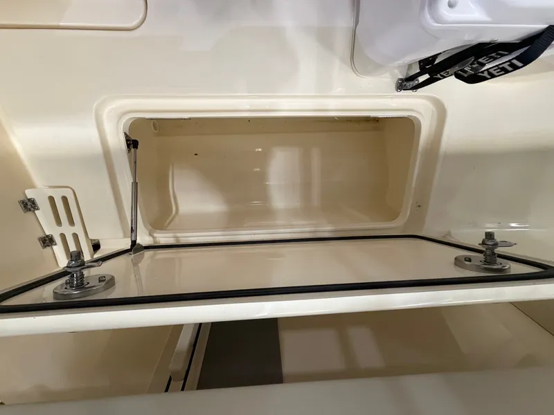Slide: The Image of An open storage compartment on a 2027 Scout 260 LXF boat. - 18