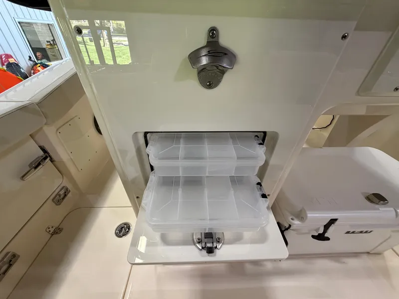 Slide: The Image of The image shows the storage area of a Scout 260 LXF boat with two transparent plastic containers. - 30