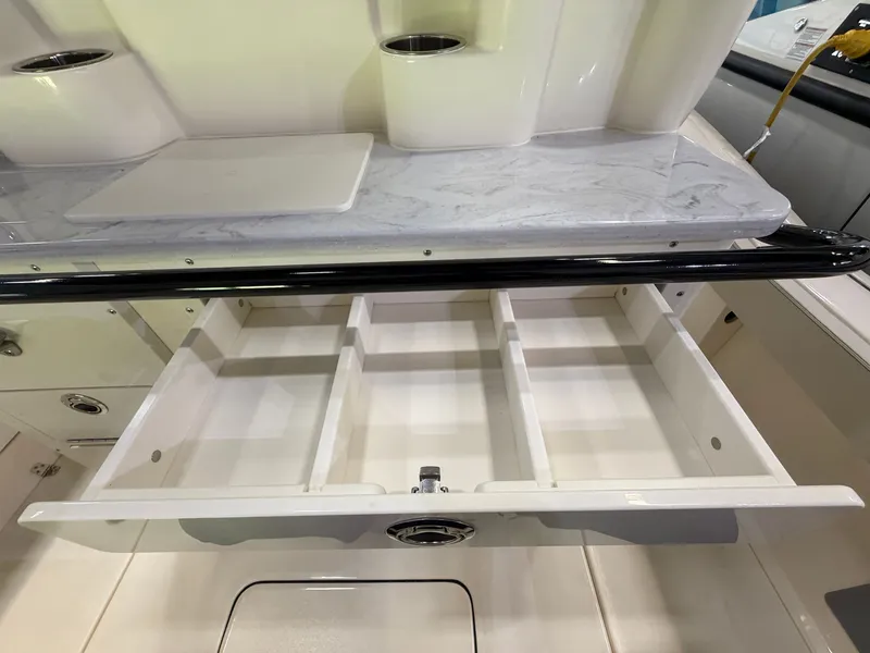 Slide: The Image of Open drawer on a boat with multiple compartments, surrounded by white interior. - 32