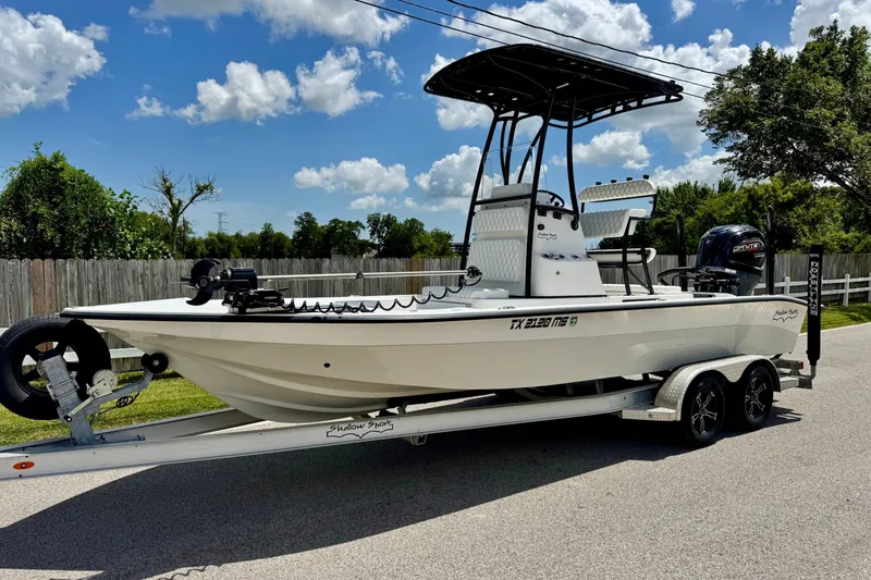 The Image of 2025 Shallow Sport 24 Modified V boat on trailer, sunny day, residential background. - 1