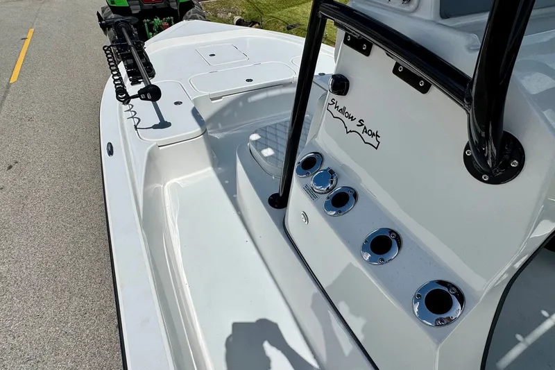 Slide: The Image of 2025 Shallow Sport 24 Modified V boat interior with rod holders and console. - 12