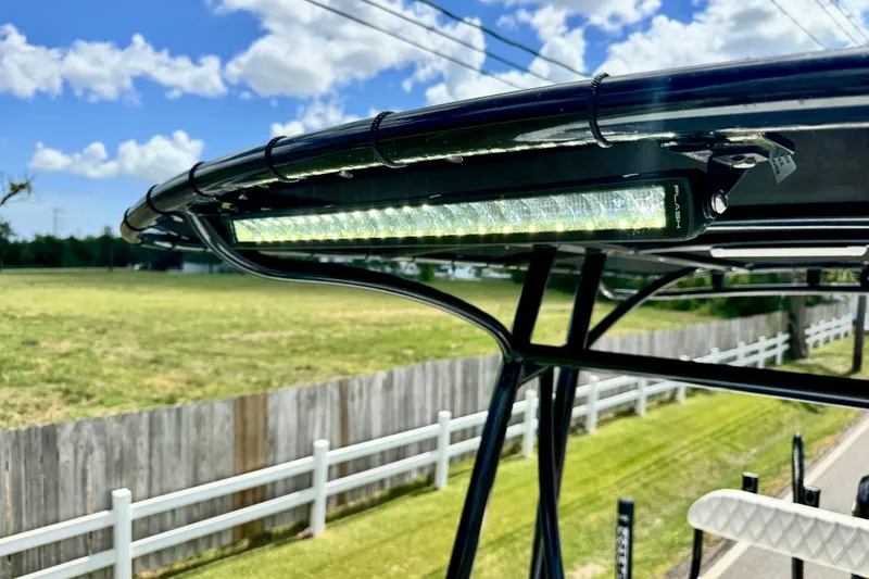 Slide: The Image of LED light bar on 2025 Shallow Sport 24 Modified V boat, sunny outdoor setting. - 18