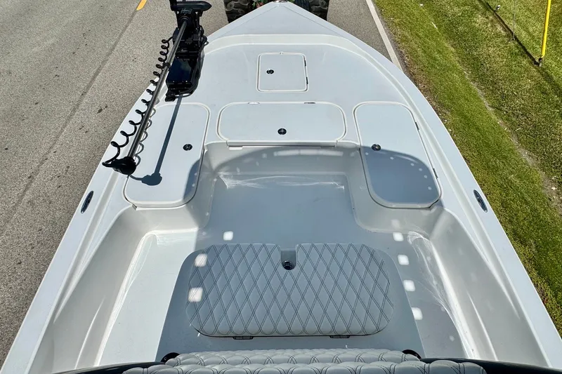 Slide: The Image of 2025 Shallow Sport 24 Modified V boat deck with storage compartments and trolling motor. - 13