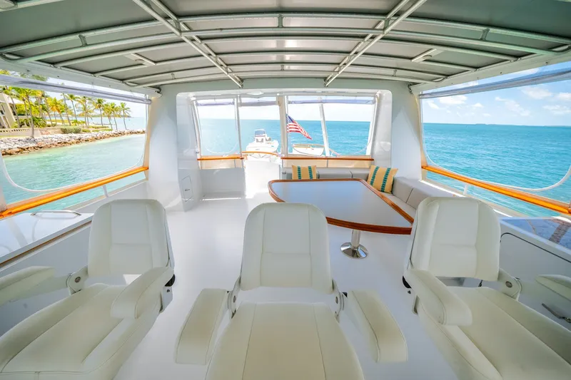 Slide: The Image of The image shows the interior of a 1992 Palmer Johnson 80 VRIPACK DOGGERS BANK yacht. There are white seats and a table overlooking the sea. - 21