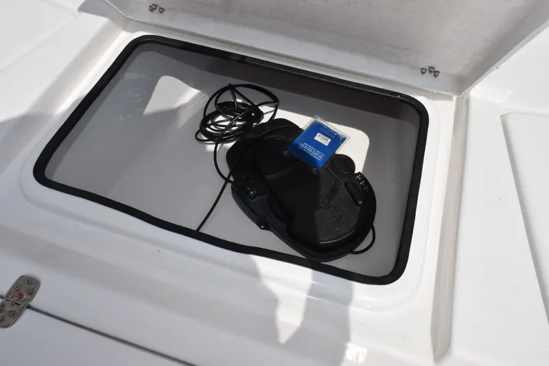 Slide: The Image of Open storage compartment in 2023 Blazer Bay 2020 boat with coiled cable and device. - 16