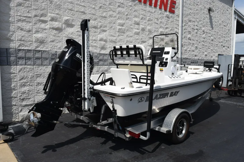 Slide: The Image of 2023 Blazer Bay 2020 boat with outboard motor, parked outside a marine store. - 4