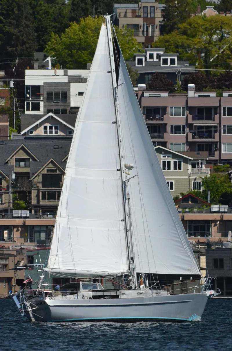 Slide: The Image of Eine weiße Segelyacht segelt vor einer städtischen Kulisse mit modernen Gebäuden. - 22
