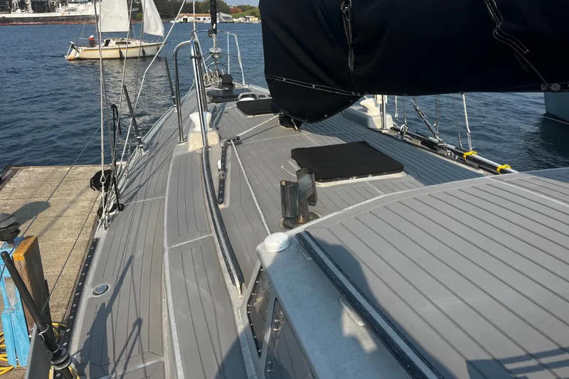 Slide: The Image of Sailboat deck view, Brewer Cutter 2005, docked at marina with water and sailboat background. - 52