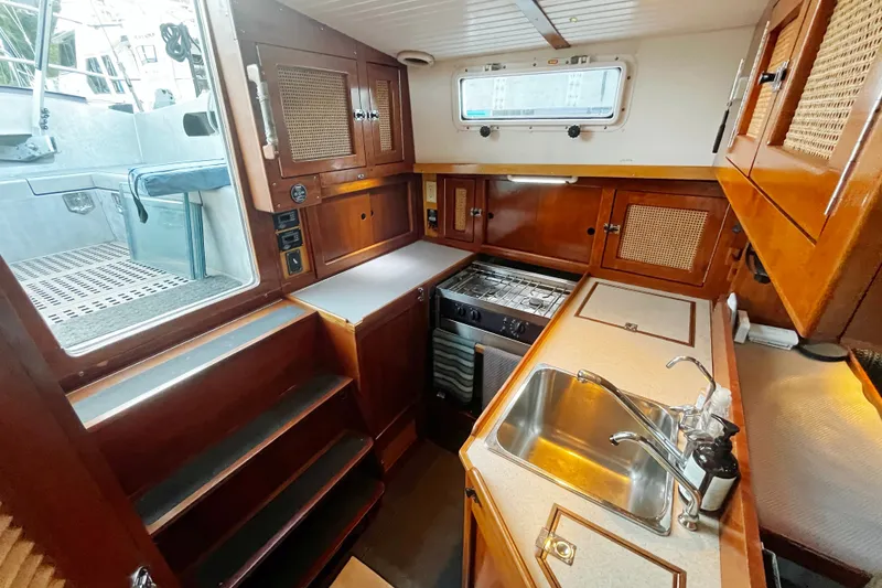 Slide: The Image of Cozy 2005 Brewer Cutter yacht kitchen with wooden cabinetry and stainless steel sink. - 13