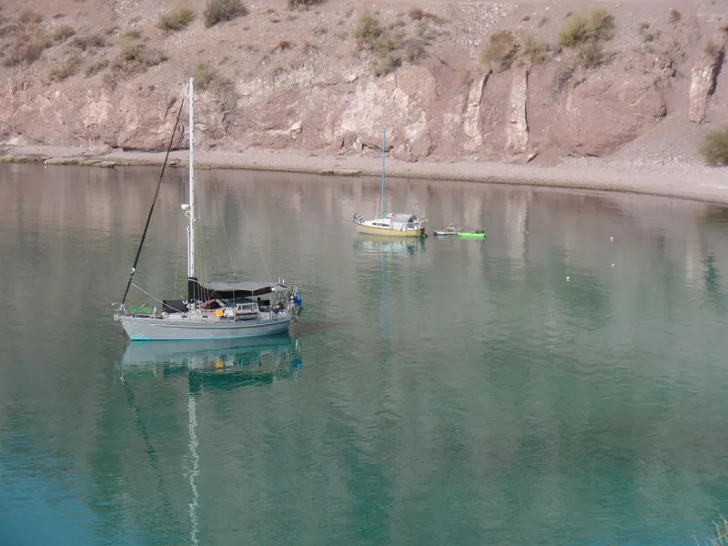 Slide: The Image of Ein Brewer Cutter von 2005 liegt in einer ruhigen Bucht mit klarem Wasser vor Anker. - 24