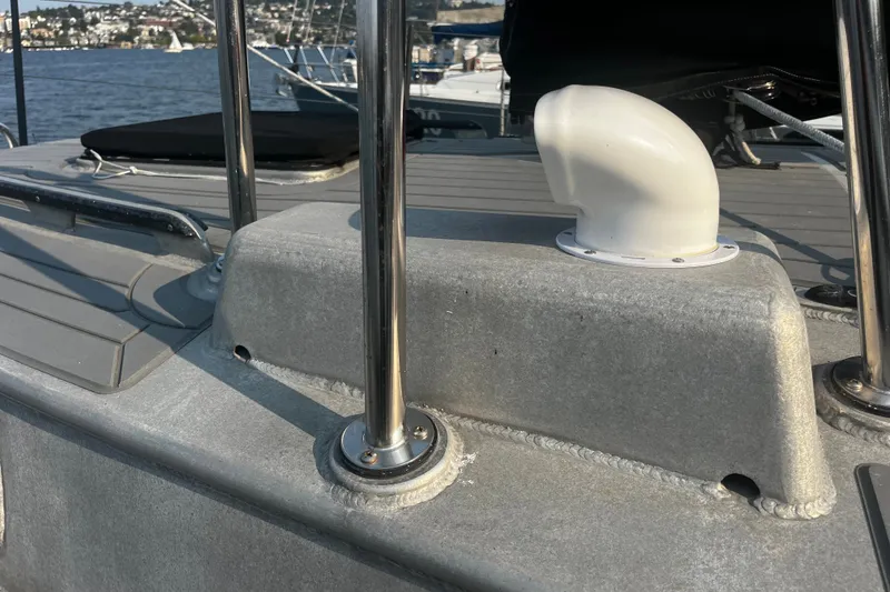Slide: The Image of Close-up of a 2005 Brewer Cutter sailboat deck with metal railings and a white vent. - 44