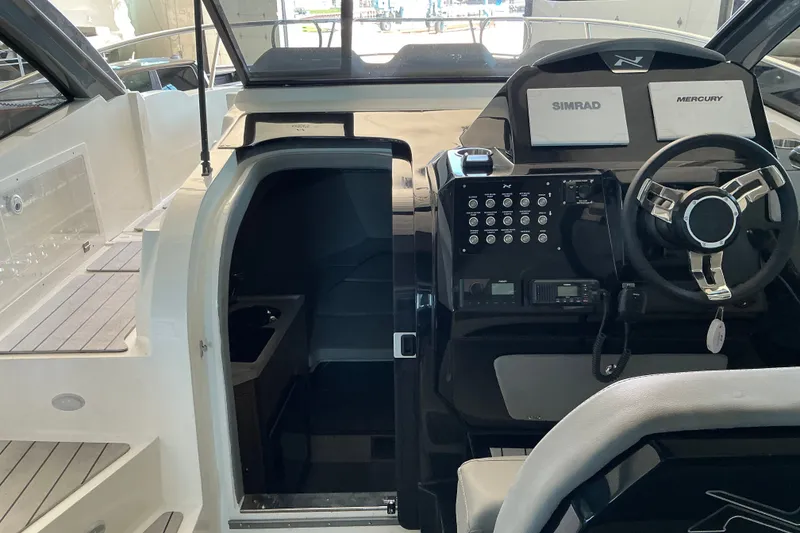 Slide: The Image of Interior view of 2026 NX Boats 360 Sport Coupe cockpit with steering wheel and control panel. - 21
