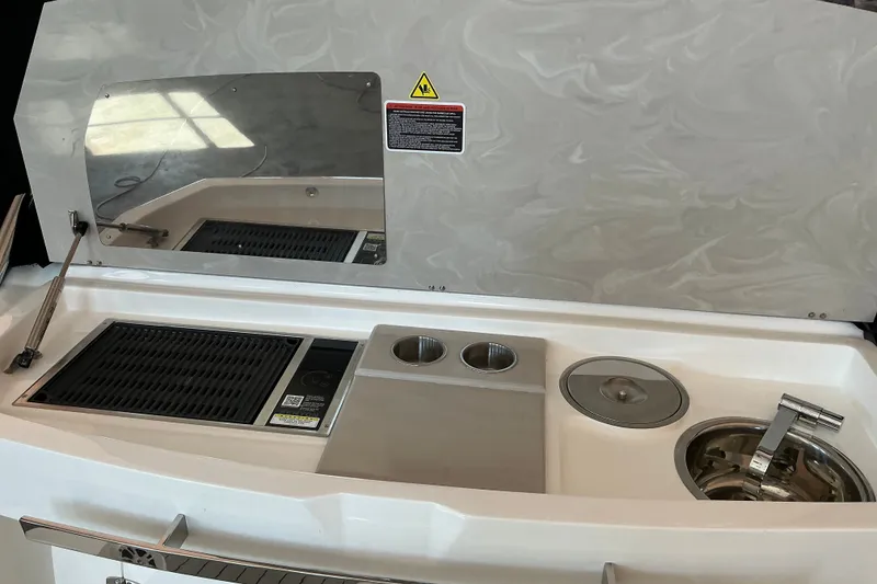 Slide: The Image of Outdoor kitchen setup on 2026 NX Boats 360 Sport Coupe, featuring grill and sink. - 14