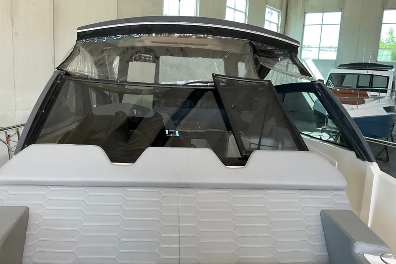 Slide: The Image of 2026 NX Boats 360 Sport Coupe interior view with modern design and sleek windshield. - 27