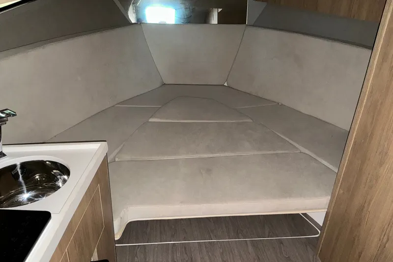 Slide: The Image of Interior of 2026 NX Boats 360 Sport Coupe, featuring a cozy seating area and compact kitchenette. - 29