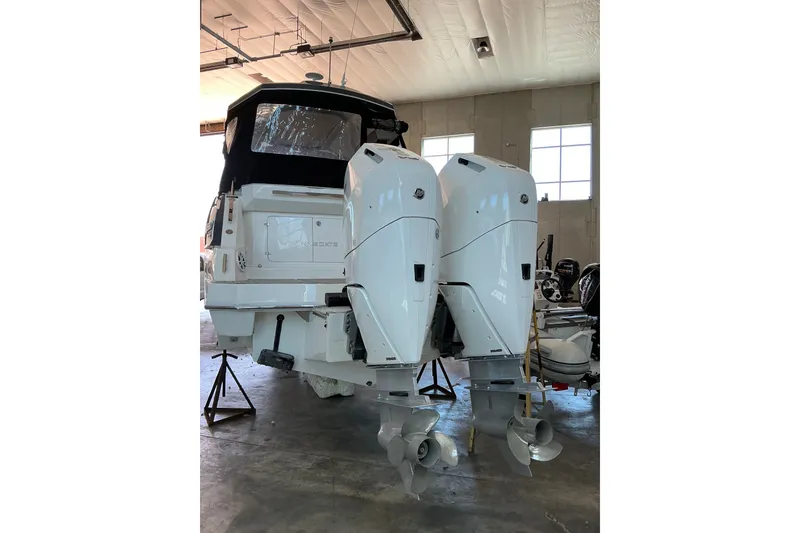 Slide: The Image of 2026 NX Boats 360 Sport Coupe with dual outboard motors in a garage setting. - 12