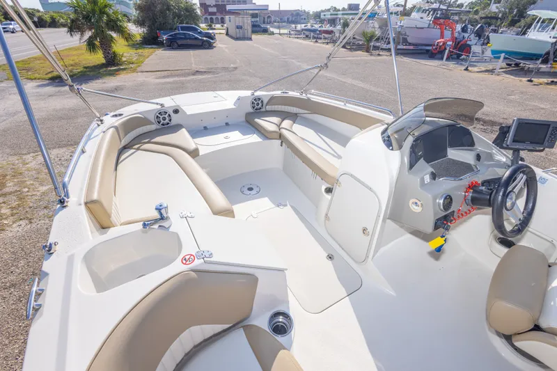 Slide: The Image of 2018 Stingray 192 SC boat interior with beige seating and modern dashboard. - 23