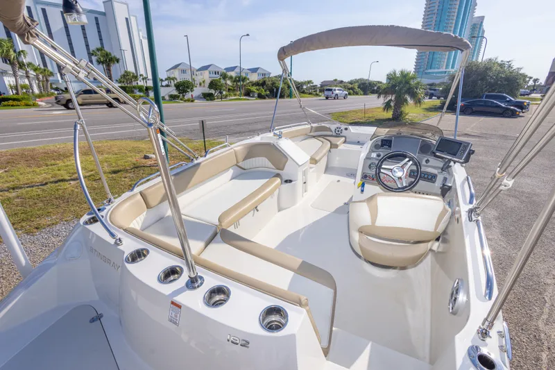 Slide: The Image of 2018 Stingray 192 SC boat interior with beige seating and modern dashboard. - 20