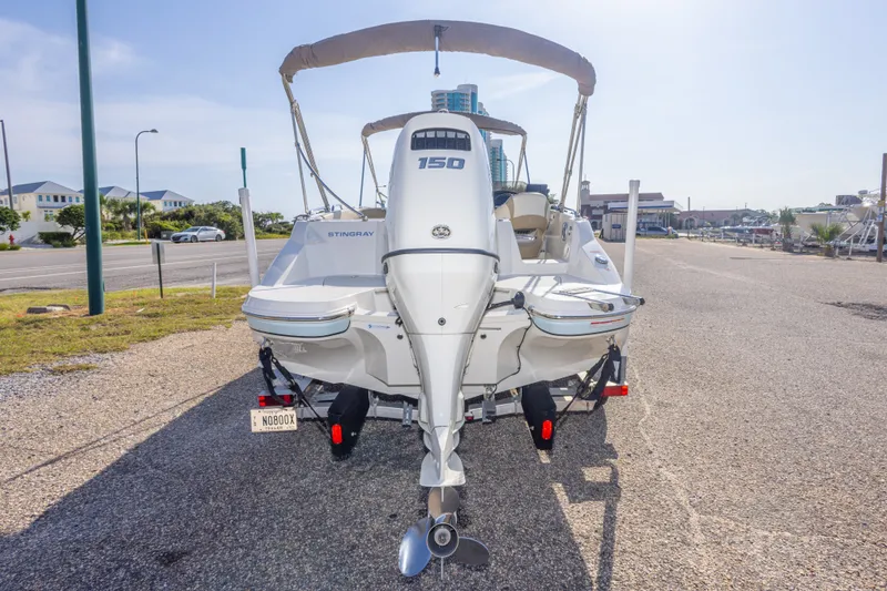 Slide: The Image of 2018 Stingray 192 SC boat with outboard motor, parked on a sunny day. - 14