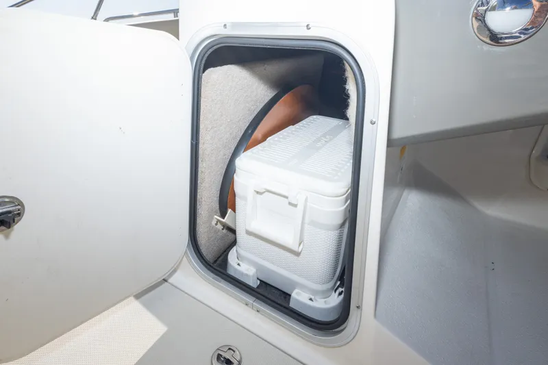 Slide: The Image of Storage compartment with cooler inside a 2018 Stingray 192 SC boat. - 40