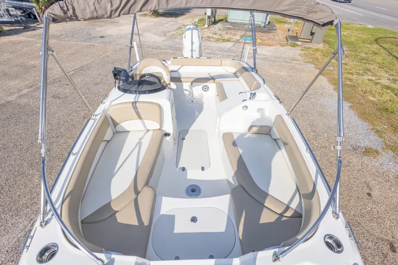 Slide: The Image of 2018 Stingray 192 SC boat interior with beige seating and canopy. - 27