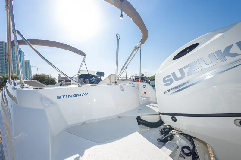 Slide: The Image of 2018 Stingray 192 SC boat with Suzuki outboard motor in sunny marina. - 44