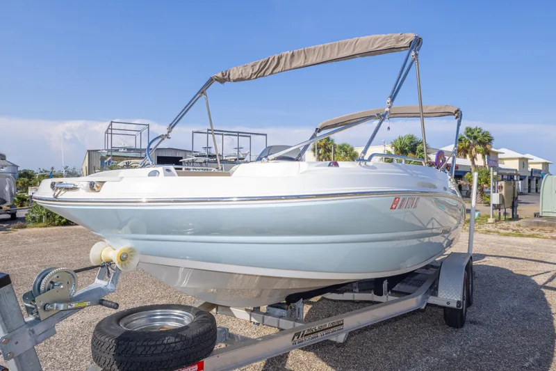 Slide: The Image of 2018 Stingray 192 SC boat on trailer, sunny day, marina background. - 18