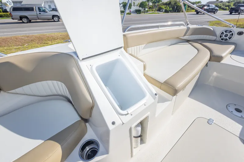 Slide: The Image of 2018 Stingray 192 SC boat interior with beige seating and open storage compartment. - 33