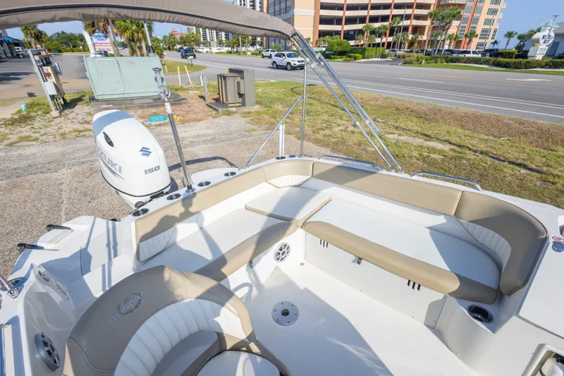 Slide: The Image of 2018 Stingray 192 SC boat with Suzuki 150 engine, beige seating, and open deck. - 36