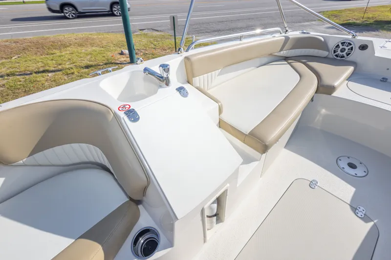 Slide: The Image of 2018 Stingray 192 SC boat interior with beige seating and a built-in sink. - 34