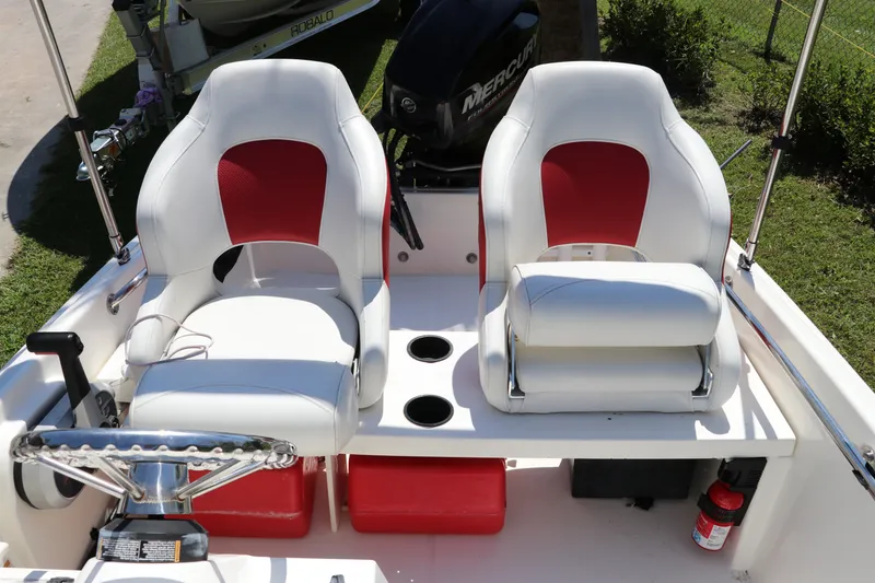 Slide: The Image of 2017 Boston Whaler 130 Super Sport boat interior with dual white and red seats. - 13