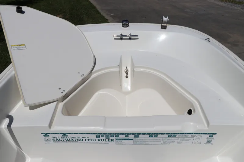 Slide: The Image of 2017 Boston Whaler 130 Super Sport boat interior with open storage compartment and saltwater fish ruler. - 22