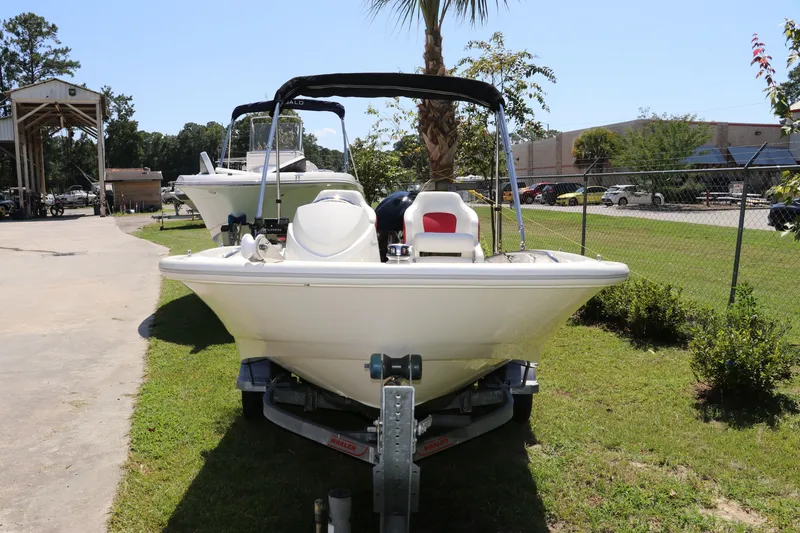 Slide: The Image of 2017 Boston Whaler 130 Super Sport boat on trailer, parked outdoors on grass. - 2