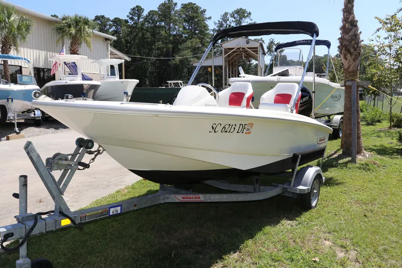 Slide: The Image of 2017 Boston Whaler 130 Super Sport boat on trailer, parked outdoors. - 3